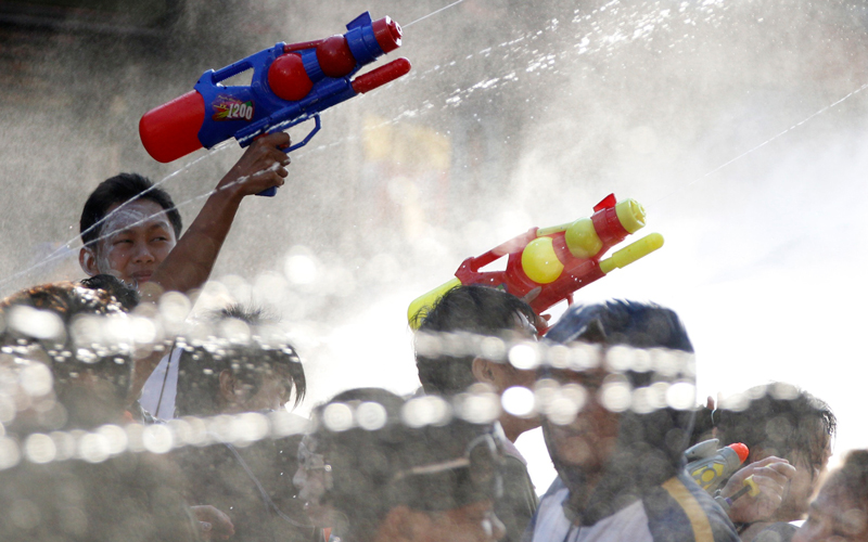 People spray water on each other as they celebrate the Songkran festival that marks the Thai new year, at the Khao San Road area in Bangkok on April 13. Thailand's Prime Minister Abhisit Vejjajiva came under mounting pressure on Tuesday to resolve a stand-off with anti-government protesters after the Election Commission recommended his party be dissolved. (Reuters)