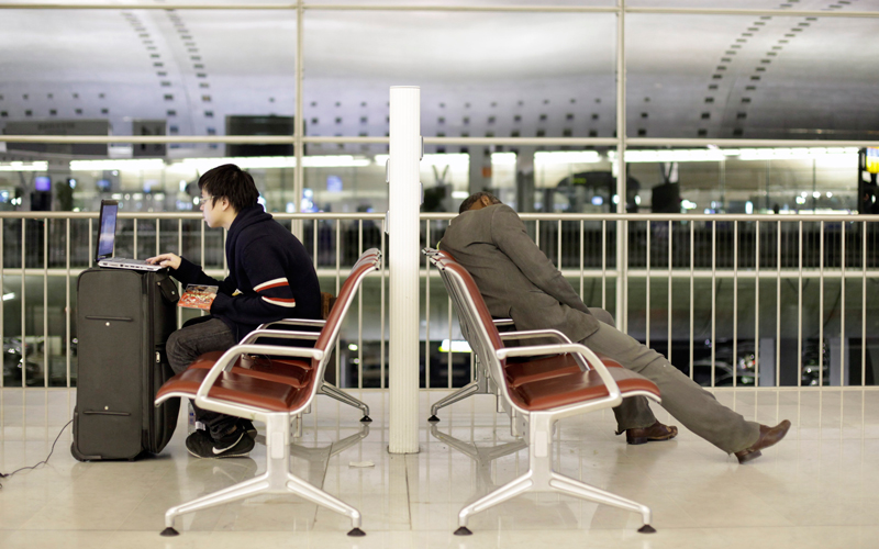 A passenger uses his computer as a homeless man sleeps, at Roissy Charles de Gaulle Airport, as hundreds of commercial flights across northern Europe have been canceled due to a drifting plume of volcanic ash originating from Iceland, outside Paris, on April 18. The Icelandic volcano that has kept much of Europe land-bound is far from finished spitting out its grit, and offered up new mini-eruptions that raise concerns about longer-term damage to world air travel and trade. (AP)