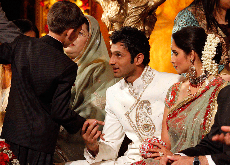 Pakistani Cricketer Shoaib Malik, talks with a boy as his wife Indian tennis star Sania Mirza looks on during their wedding reception in Sialkot, Pakistan on Sunday, April 25. The couple married last week in a ceremony that took place in the hotel at Mirza's hometown of Hyderabad, India. (AP)