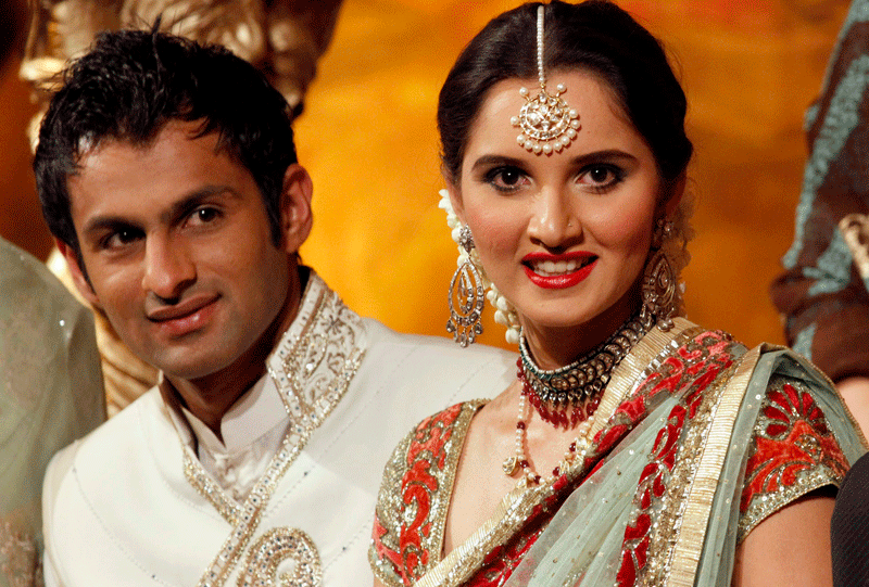 Newly wed coupled Pakistani cricketer Shoaib Malik and his wife Indian tennis star Sania Mirza smile during their wedding reception in Sialkot, Pakistan Sunday, April 25. The couple married last week in a ceremony that took place in the hotel at Mirza's hometown of Hyderabad, India. (AP)