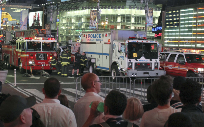 Onlookers watch after parts of New York's Times Square were closed off May 1, 2010. The dark-colored sports utility vehicle which triggered the evacuation of Times Square on Saturday night was found to contain explosives, gasoline, propane and burned wires, a New York Fire Department officer told Reuters. (REUTERS)