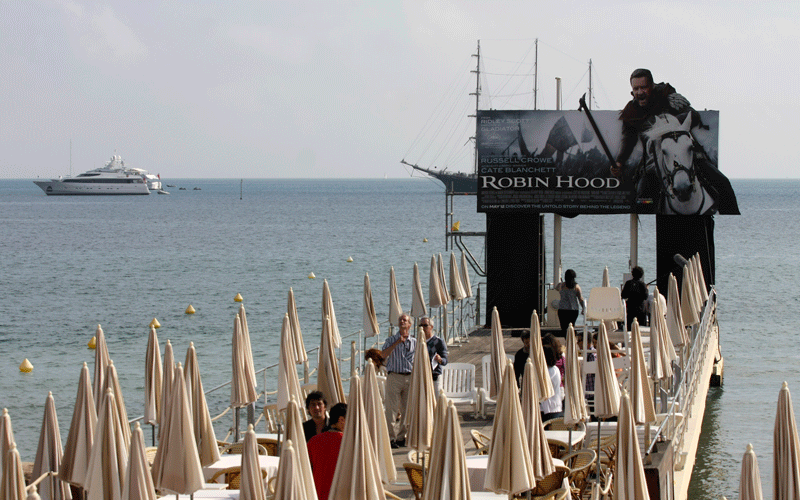 In this photo taken on May 11, 2010, people walk on a pier with a banner for the film Robin Hood, on the eve of the 63rd international film festival, in Cannes, southern France. (AP)