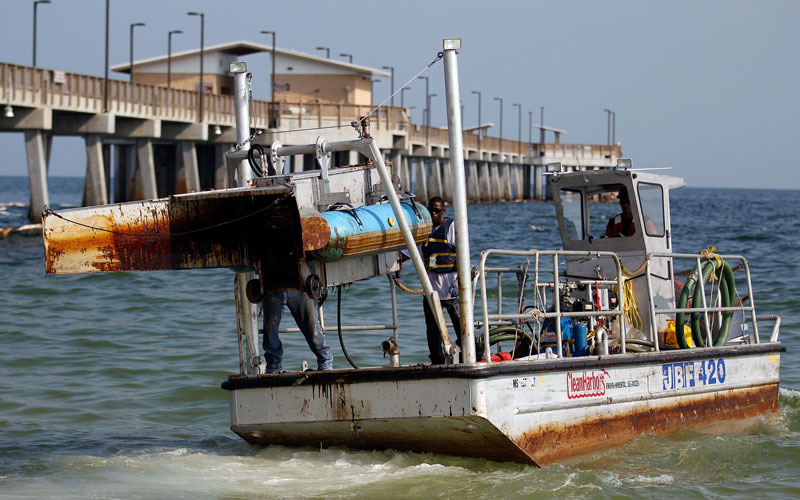 A boat covered in oil used to haul up boom is seen departing the beach on June 14, 2010 in Gulf Shores, Alabama. U.S. government scientists have estimated that the flow rate of oil gushing out of the ruptured Deepwater Horizon oil well in Gulf of Mexico may be as high 40,000 barrels per day.  (AFP)