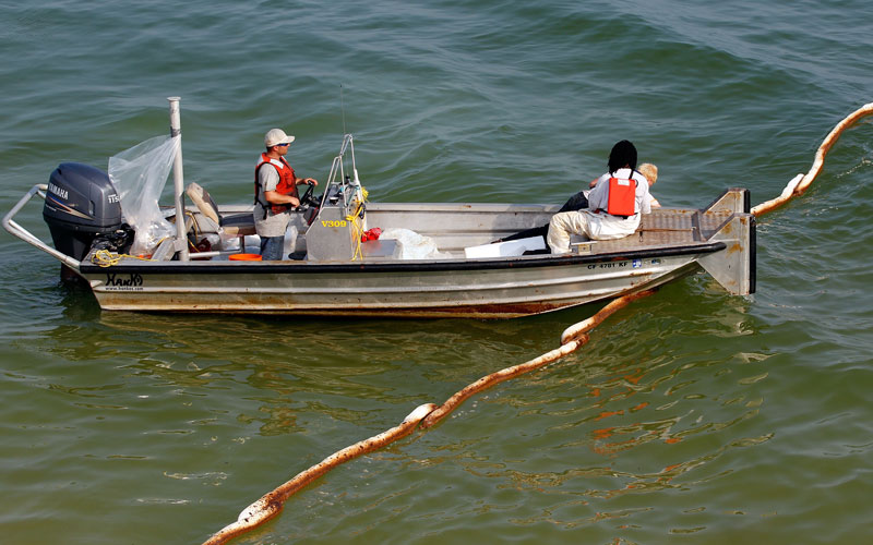 Workers lay out new lines of boom along a pier on June 14, 2010 in Gulf Shores, Alabama. U.S. government scientists have estimated that the flow rate of oil gushing out of the ruptured Deepwater Horizon oil well in Gulf of Mexico may be as high 40,000 barrels per day. (AFP)