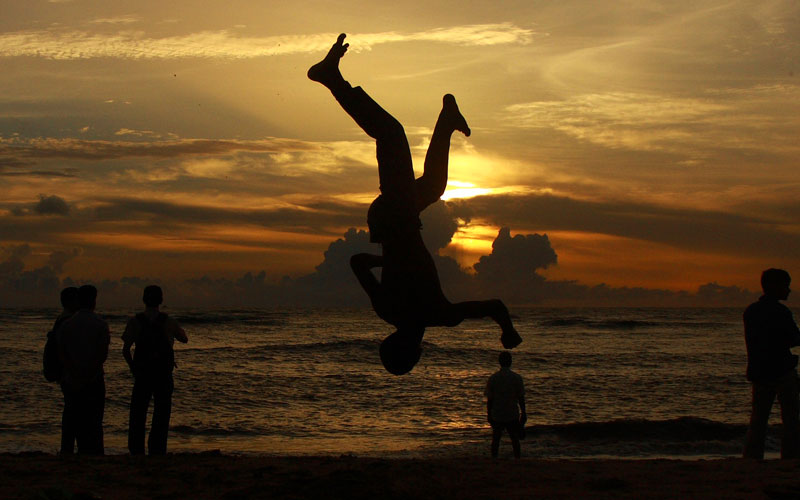 A boy somersaults on a beach against the backdrop of monsoon clouds in the southern Indian city of Kochi. Monsoon rains, vital for farm output in India's trillion-dollar economy, hit the country's southern coast in the month of May, as scheduled. (REUTERS)