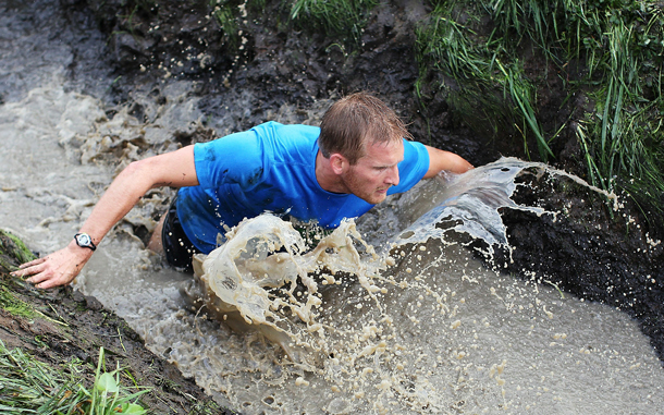 A contestant makes his way through a muddy trench during the Tough Bloke Challenge 2010 series at Woodhill in Auckland, New Zealand. The event sees thousands of men and women test their strength and endurance across a 6km or 12km cross country course consisting of man-made and natural obstacles including rivers, barbed wire and plenty of mud, all in aid of charity.  (GETTY IMAGES)