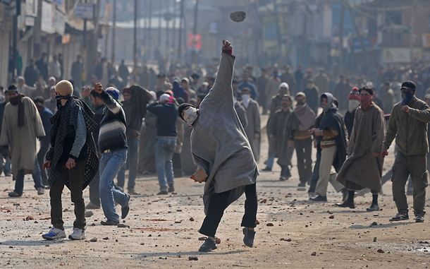 Kashmiri protesters throw stones towards Indian police during a protest in downtown Srinagar against the death of Wamiq Farooq. Thousands of Hindu pilgrims are trekking along slippery trails to reach a shrine high in the mountains of Indian Kashmir, despite violent protests in the Muslim-majority region. (AFP)