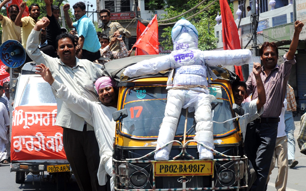 Communist Party of India (Marxist) (CPI-M) supporters shout slogans as they drive an autorickshaw with an effigy representing the national government tied to its window screen during a nationwide strike in protest of fuel price hikes in Amritsar. Police came out in force in cities across India for an opposition-led national strike over fuel price rises that disrupted flights and train services, and closed schools and businesses. The strike was called by the main opposition Bharatiya Janata Party (BJP) and leftist parties in a concerted show. (AFP)