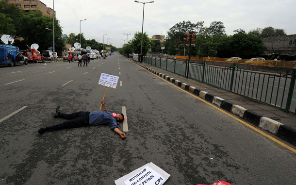 An Indian activist of the Communist Party of India (Marxist) (CPI-M) lies on the road to block traffic during a nationwide strike in protest of fuel price hikes in New Delhi. Police came out in force in cities across India for an opposition-led national strike over fuel price rises that disrupted flights and train services, and closed schools and businesses. The strike was called by the main opposition Bharatiya Janata Party (BJP) and leftist parties in a concerted show of strength against the Congress-led government's reform programme. (AFP)