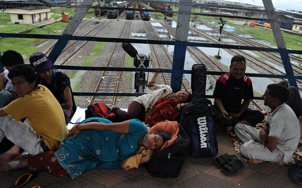 Stranded travellers wait on a platform bridge at the NJP railway station during a strike in Siliguri. An opposition-led strike over fuel price rises disrupted life across India, triggering transport mayhem and sporadic violence in major cities where schools and businesses closed down. (AFP)