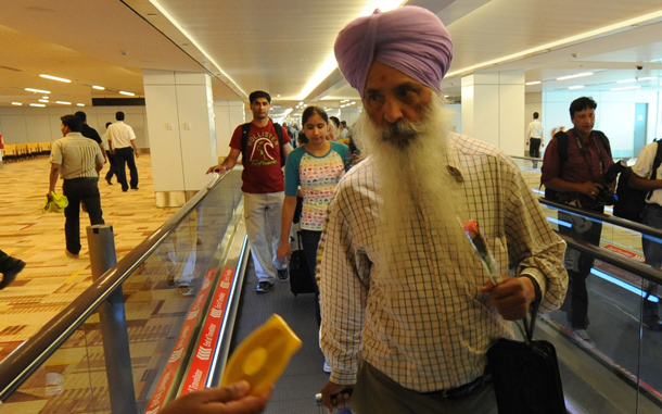 Passengers on an Air India flight from New York walk on a travelator as they arrive at terminal T-3 of Indira Gandhi International airportin New Delhi. An Air India plane carrying more than 200 passengers from New York became the first commercial flight to land at New Delhi's new, 2.7-billion-dollar airport terminal. (AFP)