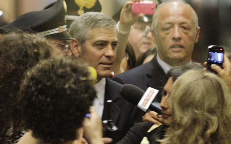 US actor George Clooney, centre, arrives through a back way at Milan's Law court on Friday to appear as a witness in a fraud trial against defendants charged with using his name for a line of clothing. (AP)