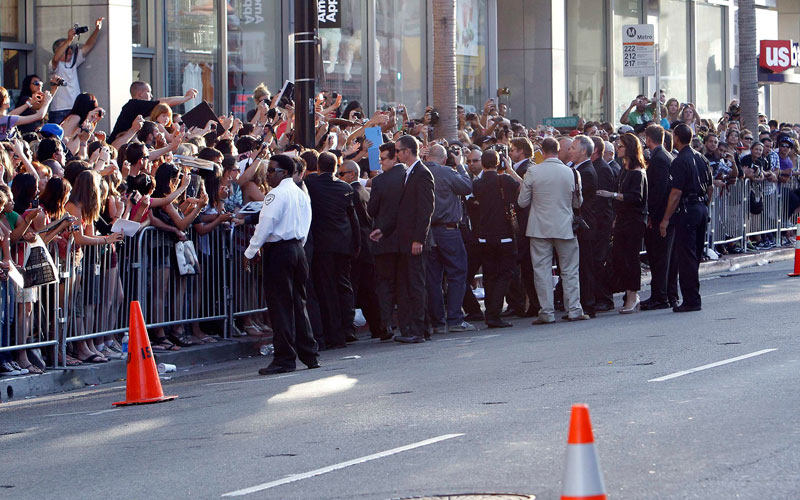 Cast member Angelina Jolie and actor Brad Pitt surrounded by security personnel and photographers greet fans at the premiere of the movie "Salt" at the Grauman's Chinese theatre in Hollywood, California July 19, 2010. (REUTERS)