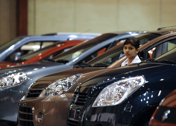 Indian sales promotion assistant stands between Maruti Suzuki cars on display at The Hyderabad International Auto Show 2010 at The Hyderabad International Convention Centre (HICC) in Hyderabad. The event in the southern Indian city will continue until July 25. (AFP)