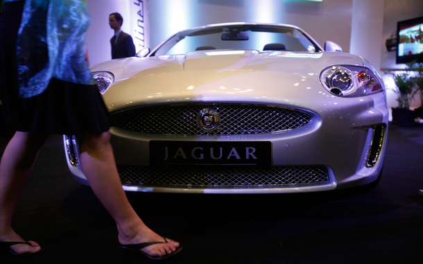 A model walks beside a Jaguar displayed at the Hyderabad International Auto Show in Hyderabad, India. (AP)