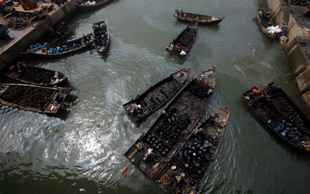 Local fishermen work to clean up the oil, which has spread far from the original explosion site in Xingang port, Dalian, northeastern China. The first details emerged Friday on the cause of China's largest reported oil spill, while environmentalists urged the government to do more to warn local residents of potential danger, saying children are playing still off nearby beaches. (AP)