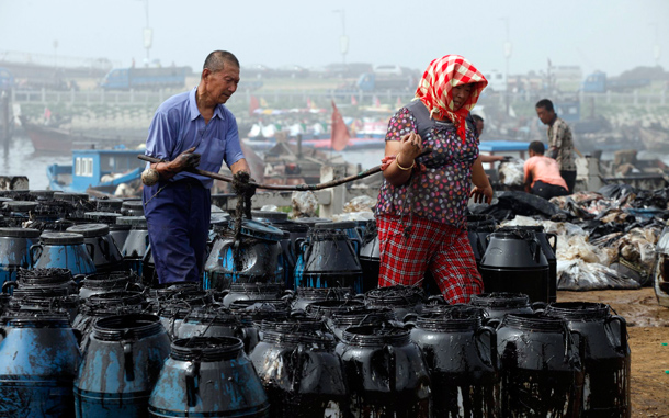 A clearing oil in the Chinese port of Dalian. Chinese authorities have closed several beaches and an island resort near the major port of Dalian as they try to clean up an oil spill that has affected crude shipments, state media said. (AFP)