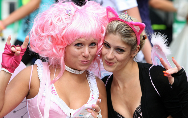 Two women attend the Love Parade festival in Duisburg, Germany. At least 18 people were crushed to death and dozens injured in a stampede at Germany's famous Love Parade festival. Thousands of other revelers kept partying at the event unaware of the deadly stampede that started when police tried to block thousands more people from entering the already-jammed parade grounds. (GETTY IMAGES)