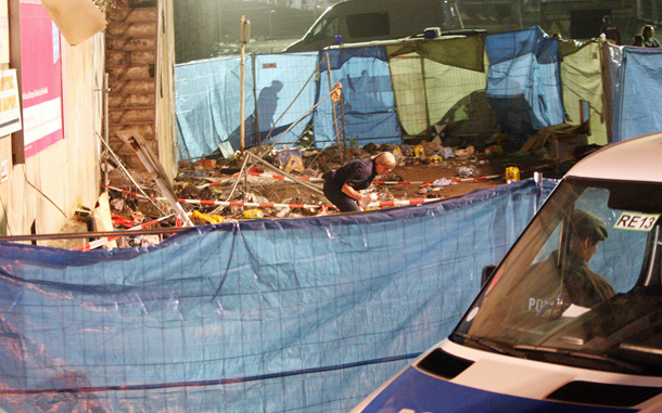 A researcher investigates the site near a staircase that many of the victims used as an escape route after at least 15 people were crushed to death and dozens injured in a stampede at Germany's famous Love Parade festival in Duisburg, Germany. Thousands of other revelers kept partying at the event unaware of the deadly stampede that started when police tried to block thousands more people from entering the already-jammed parade grounds. (GETTY IMAGES)