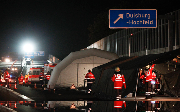 German rescuers rest in a tent that has been set up on the motorway A 59 in downtown Duisburg to care for victims of a stampede during the "Love Parade". At least 15 people were killed and some 80 people were injured in a stampede at the "Love Parade" techno music festival in the western German city on Saturday, after overcrowding at an entrance gate sparked a stampede, police said. (REUTERS)