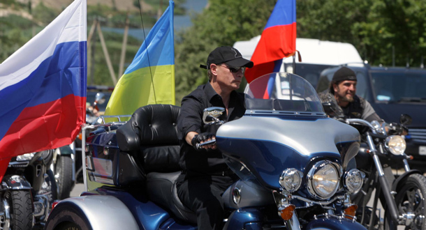 Russia's Prime Minister Vladimir Putin (C) rides a Harley Davidson Lehman Trike decorated with Russian and Ukrainian national flags as he arrives for the meeting with motorbikers at their camp near Sevastopol in Ukraine's Crimea. (EPA)