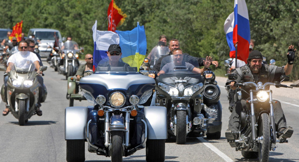 Russia's Prime Minister Vladimir Putin (C) rides a Harley Davidson Lehman Trike decorated with Russian and Ukrainian national flags as he arrives for the meeting with motorbikers at their camp near Sevastopol in Ukraine's Crimea. (EPA)