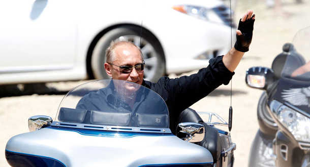 Russia's Prime Minister Vladimir Putin waves while riding Harley Davidson Lehman Trike as he arrives for the meeting with Russian and Ukrainian motorbikers at their camp near Sevastopol in Ukraine's Crimeal. (EPA)