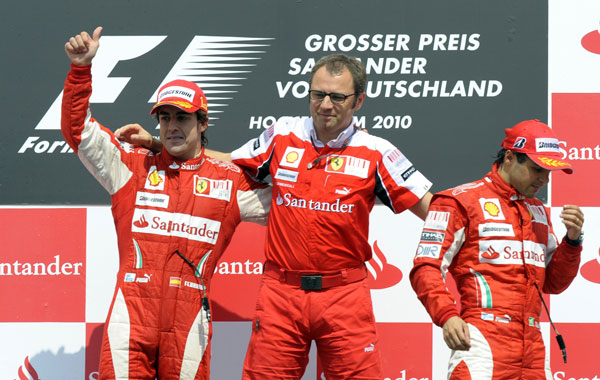 (From left) Ferrari's Spanish driver Fernando Alonso, Ferrari's team principal Stefano Domenicali and Ferrari's Brazilian driver Felipe Massa pose on the podium of the Hockenheimring circuit in Hockenheim, after the Formula One German Grand Prix. (AFP)