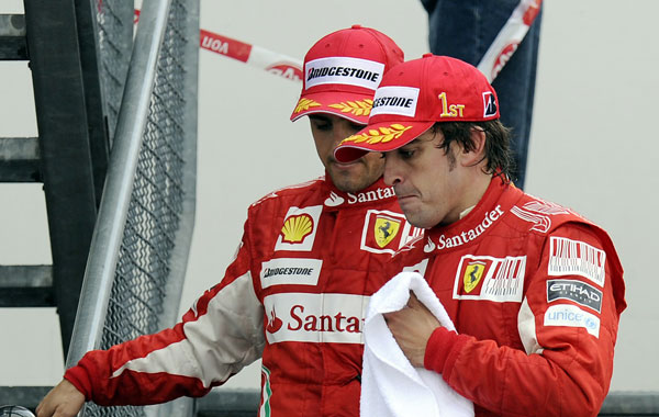 Ferrari Formula One driver Fernando Alonso of Spain, right, and teammate Felipe Massa of Brazil leaving the podium after the ceremony of the German Formula One Grand Prix in Hockenheim, Germany. (AP)