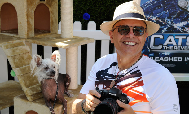 Cast member Joe Pantoliano holds a camera next to a Chinese Crested dog named Maggie, who also appears in the film, as he attends the premiere of the film "Cats & Dogs, The Revenge of Kitty Galore" in Los Angeles. (REUTERS)