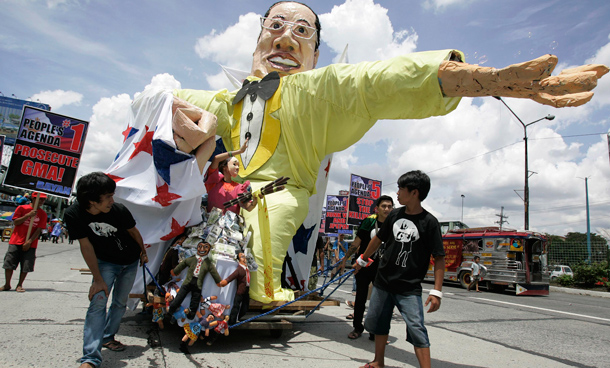 Activists pull an effigy of Philippine President Benigno Aquino III as they march towards the House of Representatives, where Aquino is set to deliver his first State of the Nation Address in suburban Quezon City, north of Manila, Philippines. Protesters are calling on Aquino to prosecute former President Gloria Macapagal Arroyo and stop political killings. (AP)