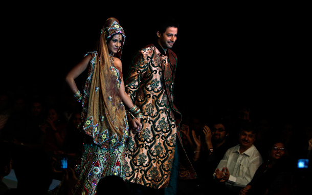 Indian actors Zulfi Sayed, right, and Bindu present creations by Mubeen Fatima at Bangalore Fashion Week in Bangalore. (AP)