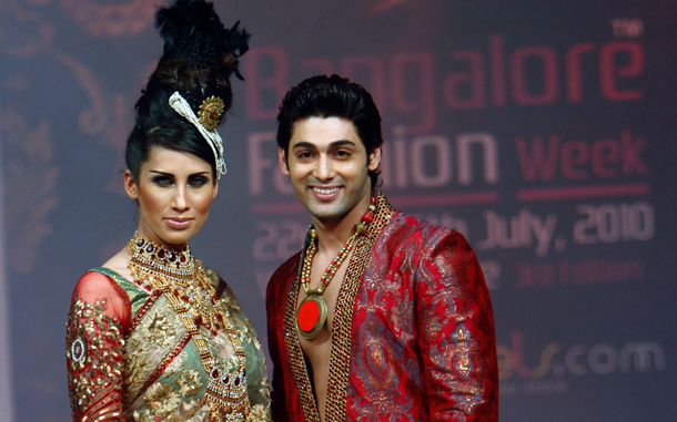 Bollywood actor Ruslaan Mumtaz, right, who was dropped from Slumdog Millionaire because he was too good-looking, poses with a model in creations by Ramesh Dembla at Bangalore Fashion Week. (AP)