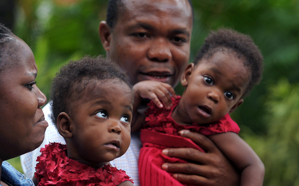 Nigerian parents Comfort Adugbe (L) and Emmanuel Adugbe respectively hold daughters Peace and Patience, recently separated 8-month old conjoined twins, at a press meet in Bangalore. Peace and Patience were operated last month by a team of 24 medical personnel. The twins, who were joined at the abdomen, sharing liver and intestine, and are called omphalopagus, are set to fly home to Nigeria in the evening. (AFP)