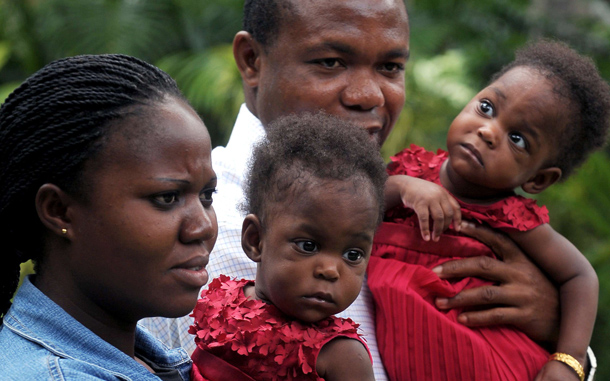 Nigerian parents Comfort Adugbe (L) and Emmanuel Adugbe respectively hold daughters Peace and Patience, recently separated 8-month old conjoined twins, at a press meet in Bangalore. Peace and Patience were operated last month by a team of 24 medical personnel. The twins, who were joined at the abdomen, sharing liver and intestine, and are called omphalopagus, are set to fly home to Nigeria in the evening. (AFP)