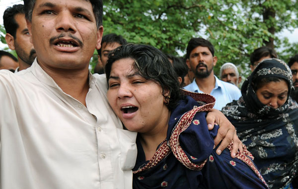 A Pakistani man comforts a woman as she mourns the death of her father, killed in a passenger plane crash in The Margala Hills on the outskirts of Islamabad. (AFP)