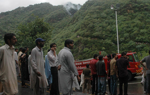 Local residents look towards the site of a plane crash in Islamabad, Pakistan. (AP)