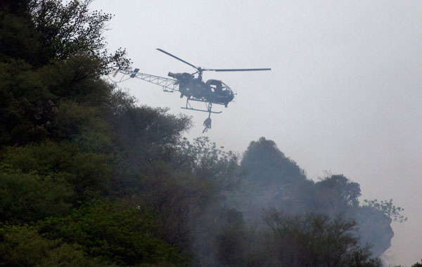 A Pakistani Army helicopter hovers as it looks for survivors of a passenger plane crash in mountains of Islamabad, Pakistan. (AP)