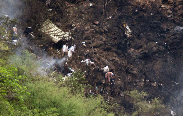 Pakistani rescue workers look for survivors at the site of a passenger plane crash in mountains of Islamabad, Pakistan. (AP)