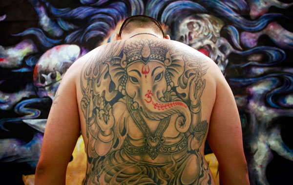 An artist displays his back in front of his exhibition booth at the 2010 Taiwan International Tattoo Convention in Taipei (REUTERS)