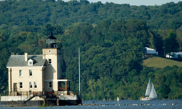 Tents are seen at Astor Courts in Rhinebeck, N.Y., right, as a sail boat moves along the Hudson River past the Rondout Lighthouse in Port Ewen, N.Y. The wedding of Chelsea Clinton and Marc Mezvinsky was taking place at Astor Courts. (AP)