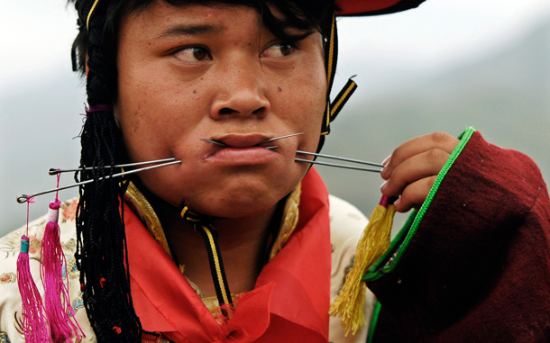 A Tibetan man has his mouth pierced with steel needles during the Lurol festival in Rebkong, known in Chinese as Tongren, in Qinghai province. The annual religious festival is held during the sixth month of the Tibetan lunar calendar with sacrificial performances for the Gods, who visit villagers through human mediums. (REUTERS)