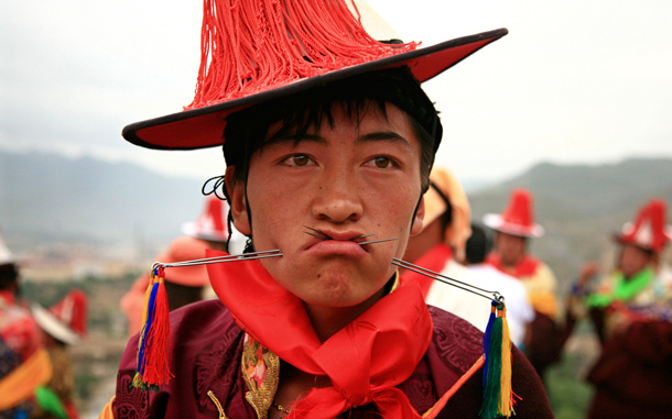 A Tibetan man has his mouth pierced with steel needles during the Lurol festival in Rebkong, known in Chinese as Tongren, in Qinghai province. The annual religious festival is held during the sixth month of the Tibetan lunar calendar with sacrificial performances for the Gods, who visit villagers through human mediums. (REUTERS)