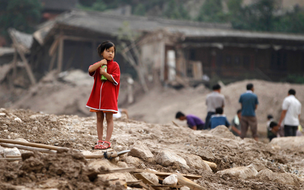 A girl stands on the debris of damaged buildings in landslide-hit Zhouqu County of Gannan Tibetan Autonomous Prefecture, Gansu Province. At least 702 people died in northwestern Gansu province when a torrent of mud and rocks engulfed swathes of the small town of Zhouqu at the weekend, and another 1,042 are missing, an emergency relief official, Tian Baozhong, told reporters there. (REUTERS)