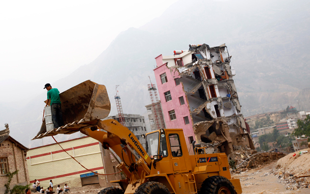 A man is carried by a bulldozer across a landslide-hit street in Zhouqu County of Gannan Tibetan Autonomous Prefecture, Gansu Province. At least 702 people died in northwestern Gansu province when a torrent of mud and rocks engulfed swathes of the small town of Zhouqu at the weekend, and another 1,042 are missing, an emergency relief official, Tian Baozhong, told reporters there. (REUTERS)