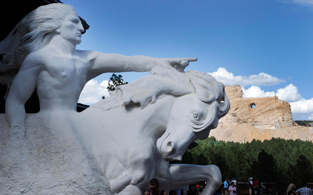 A replica of Chief Crazy Horse pointing as he rides a horse shows what the Crazy Horse Memorial (background) will look like which is being carved out of the granite Thunder Mountain in the Black Hills near Custer, South Dakota, USA. (EPA)