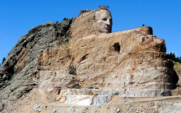 Trucks and heavy equipment vehicles at the base of the Crazy Horse Memorial are dwarfed by the colossal sculpture that is being carved out of the granite Thunder Mountain in the Black Hills near Custer, South Dakota, USA. (EPA)