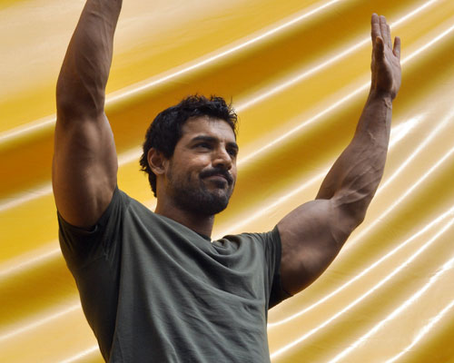 Indian Bollywood actor John Abraham waves to the crowd as he prepares to climb a hoarding at a promotional event for the forthcoming Hindi film “Jhooth hi sahi” in Mumbai. (AFP)