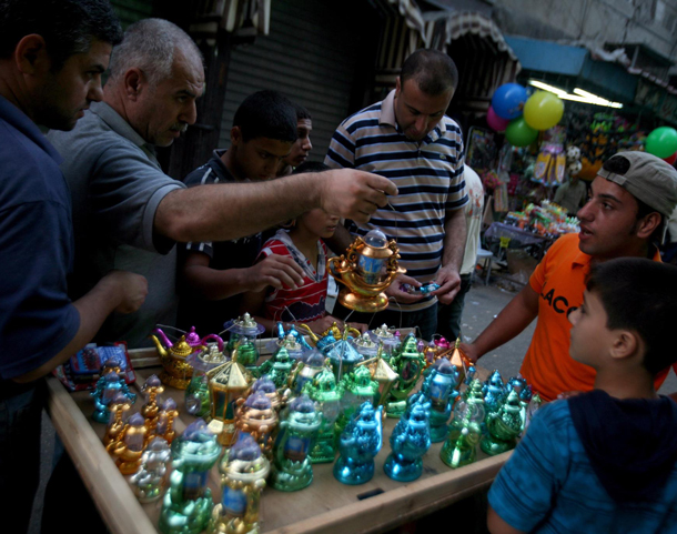 People buy goods at a market decorated for the holy fasting month of Ramadan, in Gaza City, Gaza Strip. Muslims throughout the world are celebrating the holy fasting month of Ramadan, the holiest month in Islamic calendar, refraining from eating, drinking, and smoking from dawn to dusk. (EPA)