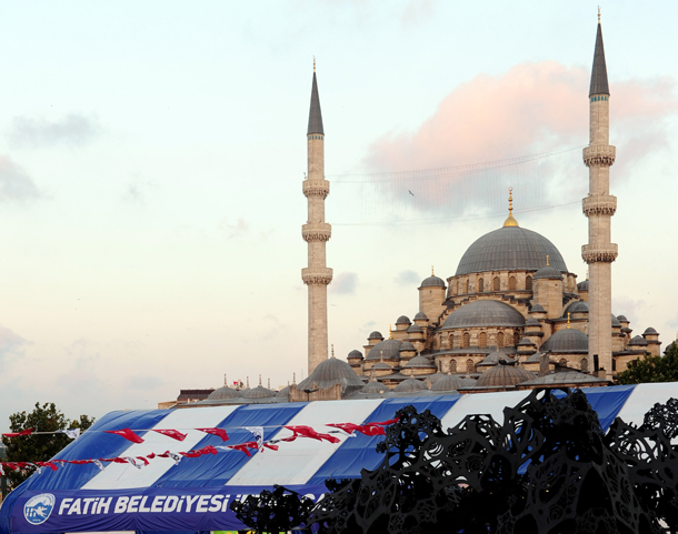 Turkish people wait in line for free food given by the Fatih district municipality in front of a tent pitched up for people for the evening meal to break the fast during the Islamic holy month of Ramadan, in Eminonu, downtown Istanbul. During the holy month of Ramadan, Muslims the world over abstain from eating and drinking from dawn til dusk. (AFP)